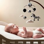 What can my 1-month old baby see: Newborn in crib with black-and-white mobile for visual development