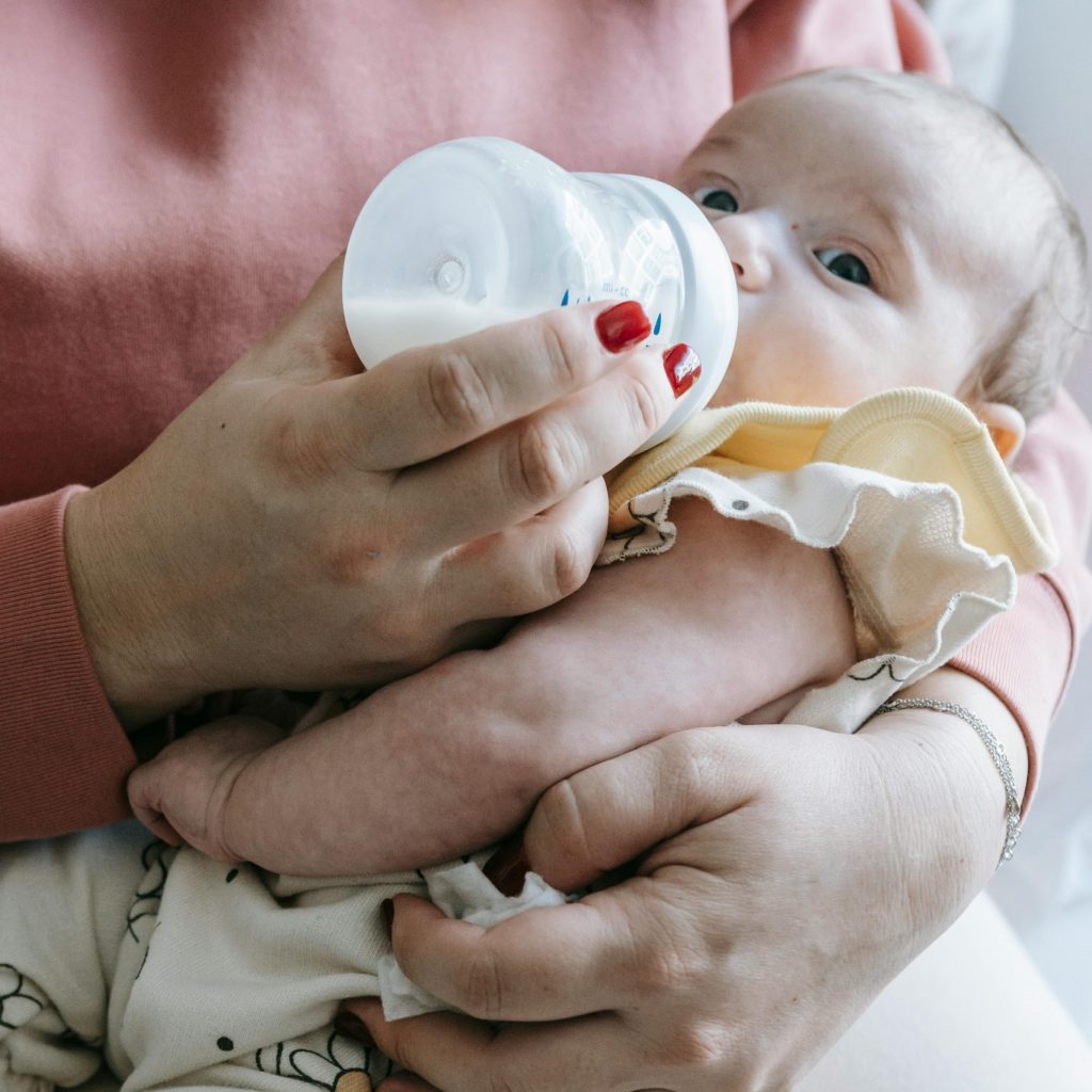 How can I tell if my baby is hungry or full? A photo of a baby feeding by bottle.